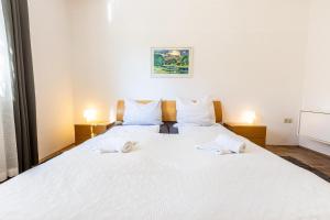 a bedroom with a large white bed with two lamps at Serviced Appartement München Messe in Munich