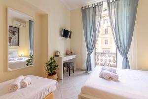 a hotel room with two beds and a window at Alveare Bed & Breakfast in Rome