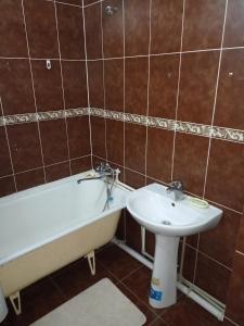 a bathroom with a bath tub and a sink at Апартаменты на Первомайская 37 "А" in Semey
