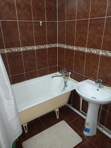 een badkamer met een bad en een wastafel bij Апартаменты на Первомайская 37 "А" in Semey