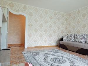 a living room with a couch and a rug at Апартаменты на Первомайская 37 "А" in Semey