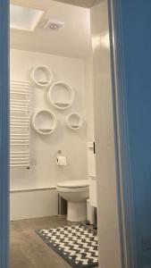 a bathroom with a toilet and three urinals on the wall at Relax by the Sea in Weymouth