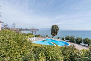 ein Schwimmbad mit dem Ozean im Hintergrund in der Unterkunft Front Lake Amazing View in Manerba del Garda