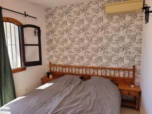 sypialnia z łóżkiem i ścianą z tapetą w obiekcie Apartamento de lujo Nerja w mieście Nerja