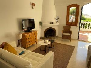 salon z kanapą, telewizorem i kominkiem w obiekcie Apartamento de lujo Nerja w mieście Nerja
