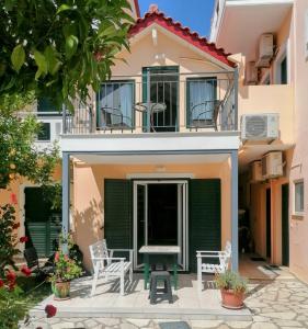 a house with a porch with chairs and a balcony at Villa Perivoli in Parga