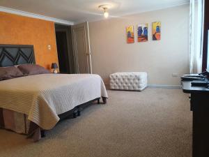 a bedroom with a bed and a chair at MONTELUX Apartamento in La Paz