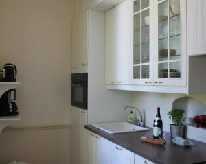 a kitchen with white cabinets and a sink at Appartement du Château du Grand Bouchet in Ballan-Miré