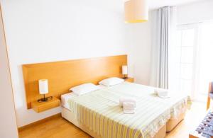 a bedroom with a large bed with two white pillows at Casa da Ria in Cabanas de Tavira