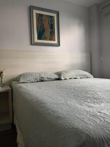 uma cama num quarto com uma fotografia na parede em House Flat Cacupé em Florianópolis em Florianópolis