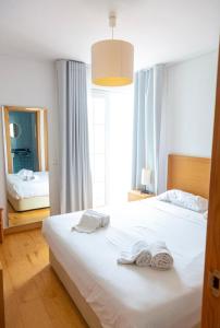 1 dormitorio con 2 toallas blancas en una cama en Casa da Ria, en Cabanas de Tavira