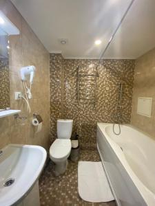 y baño con aseo, bañera y lavamanos. en Kirin Hotel en Moscú