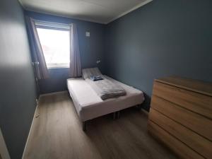 a small bedroom with a bed and a window at Lofoten, Markveien Villa in Kabelvåg