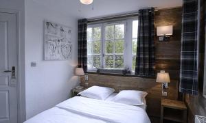 1 dormitorio con 2 camas y ventana en Le Moulin de Lily, en Palaiseau