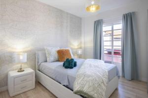 a bedroom with a bed with a night stand and a window at Family Apartment with 3 bedrooms in Puerto de la Cruz