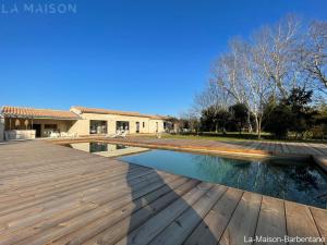 einen Pool mit einer Holzterrasse neben einem Haus in der Unterkunft La Maison Barbentane in Barbentane