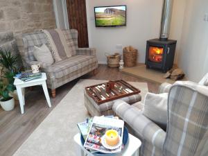 a living room with a couch and a wood stove at The Nook Cottage In The Heart Of Northumberland in Wark