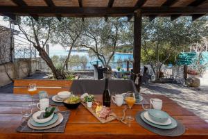 a wooden table with food and wine glasses on it at MIA mobile home with jacuzzi in Ždrelac