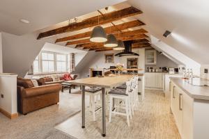 a kitchen and living room with a wooden table and chairs at The Tower Gastro Pub & Apartments in Crieff