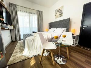 sypialnia z łóżkiem i stołem z 2 krzesłami w obiekcie Luxury Room with Marina view close to JBR Beach and Metro with Shared Kitchen w Dubaju