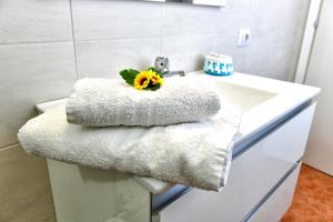 a white bathroom sink with a bunch of towels at Casa Basilia in San Teodoro +24 photos