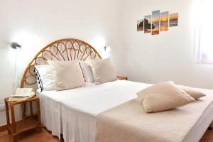 a bedroom with a large bed with white sheets and pillows at Casa Basilia in San Teodoro