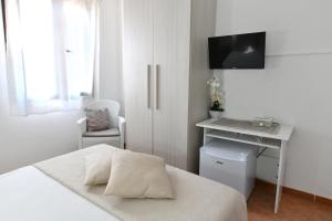 a bedroom with a bed and a desk with a television at Casa Basilia in San Teodoro