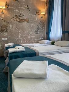 モスクワにあるKirin Hotelのベッド3台、タオル付