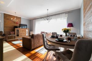 a living room with a table and a couch at Apartament Karmelowy z tarasem - Dream Apart in Wisła