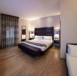 a bedroom with a large bed and a couch at Rome Airport Hotel Fiumicino in Fiumicino