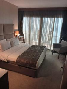 a hotel room with a large bed and a chair at Riva Reşatbey Luxury Hotel in Adana