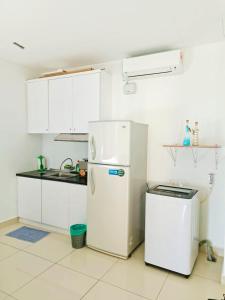 Una cocina con gabinetes blancos y un refrigerador blanco. en Mansion One Two Bedroom Seaview 7 Pax, en George Town