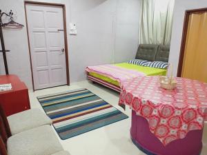 a room with two beds and a table and a door at Wan Guest House in Pasir Mas +15 photos