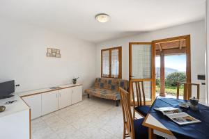 une cuisine et une salle à manger avec une table et une chambre avec un canapé dans l'établissement Villaggio Colombo V3 comfort, à Marina dʼAndora