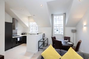 a kitchen and living room with a couch and a table at ALTIDO Contemporary and Vibrant 1BR flat near Princes Street in Edinburgh