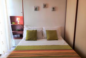 阿爾蓋羅的住宿－Casa Alice，一张带两个绿色枕头的床