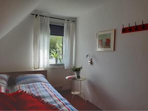a bedroom with a bed and a window and a table at Haus 5 Zehn in Werdum