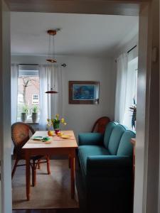 a living room with a blue couch and a table at Haus 5 Zehn in Werdum +3 photos