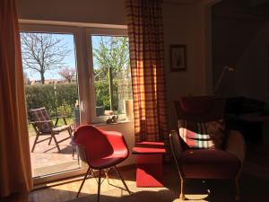 a living room with chairs and a sliding glass door at Haus 5 Zehn in Werdum