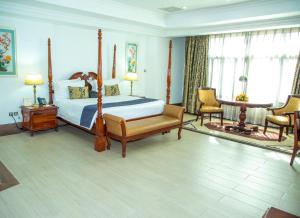 um quarto com uma cama, uma mesa e cadeiras em Weston Hotel em Nairobi
