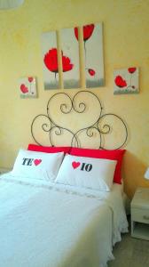 um quarto com uma cama com almofadas vermelhas e brancas em Gaia's Room B&B em Roma