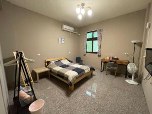 1 dormitorio con 1 cama, escritorio y cámara en Hello Guesthouse en Lugang