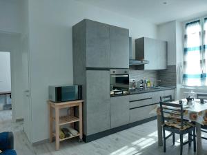 cocina con electrodomésticos de acero inoxidable y mesa en L'arco blu, en Albisola Superiore