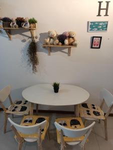stół i krzesła z misiami na półkach w obiekcie cozy seaview 5 studio apartment w mieście Tanjong Tokong
