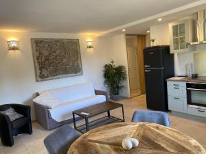 a living room with a table and a kitchen at Chambres d'Hotes Les Amandiers in Saint-Tropez