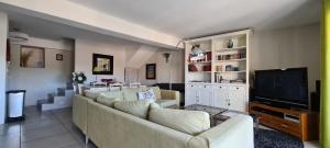 a living room with a couch and a television at La salamandre in Venterol