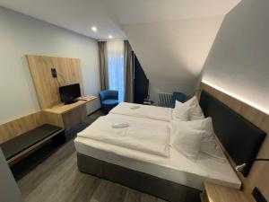 um quarto de hotel com uma cama grande e uma secretária em Zum Roten Bären em Friburgo em Brisgóvia