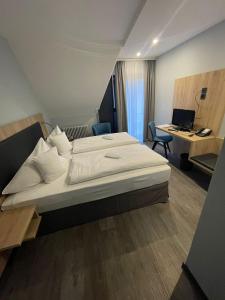 - une chambre avec un lit et un bureau avec un ordinateur dans l'établissement Zum Roten Bären, à Fribourg-en-Brisgau