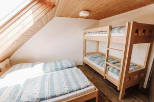 a bedroom with bunk beds in a attic at Farma Klokočov in Vítkov