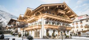 duży drewniany budynek w śniegu w obiekcie Das Krumerhaus w mieście Aschau